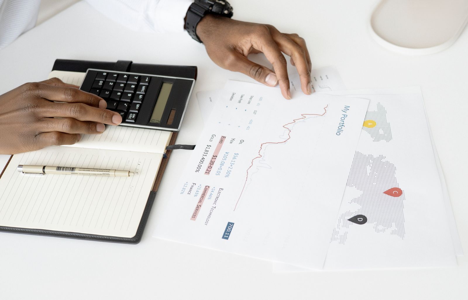 Person analysiert Finanzdokumente mit einem Taschenrechner für die Investitionsplanung
